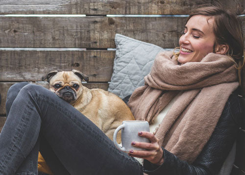Woman and pug dog enjoying Noble House Coffee